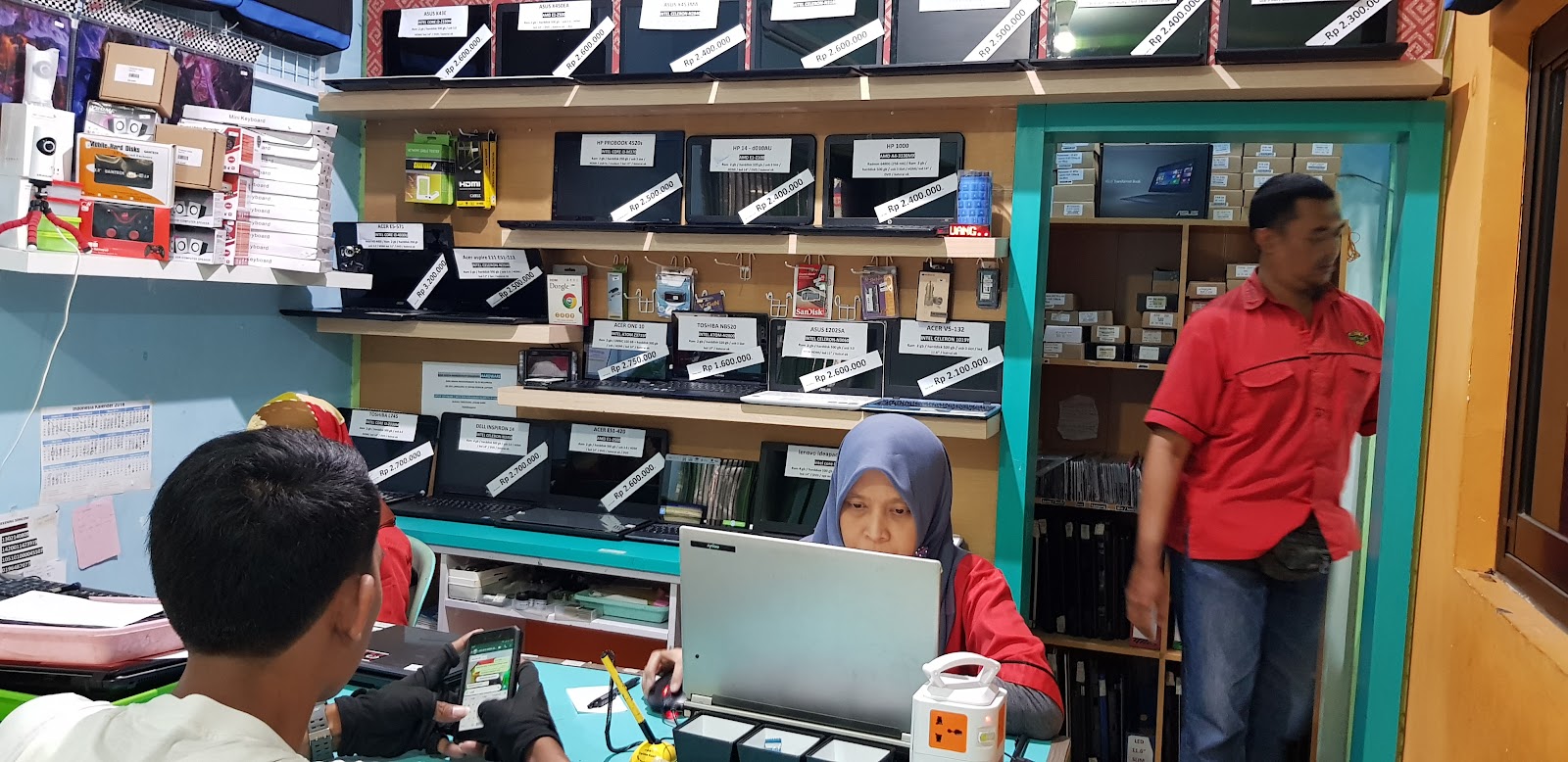 Teknisi menjelaskan hasil pemeriksaan laptop kepada pelanggan
