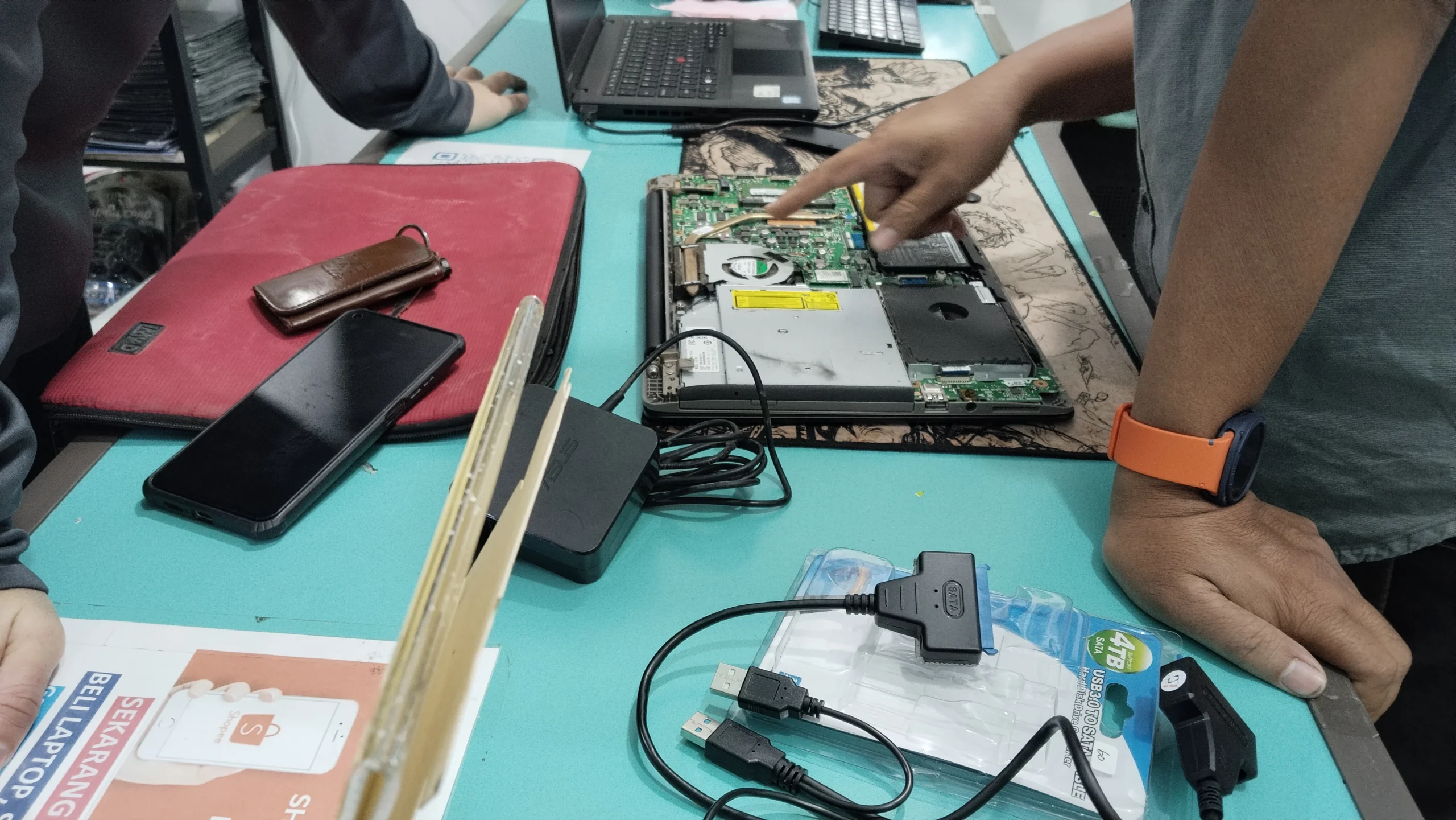Teknisi SonCom melakukan pengecekan kondisi laptop HP sebelum perbaikan
