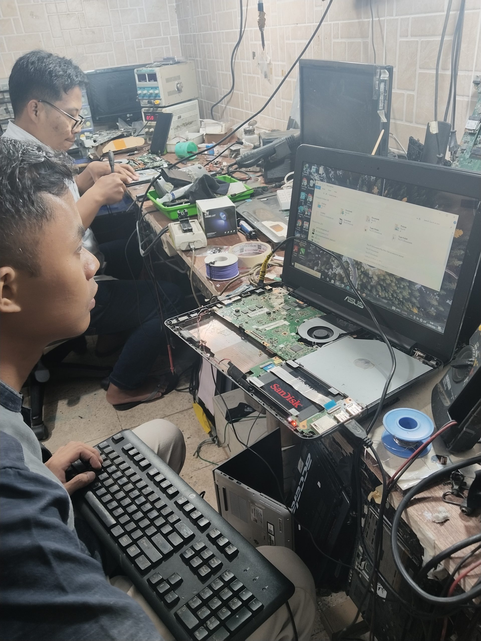 Teknisi sedang melakukan perbaikan laptop